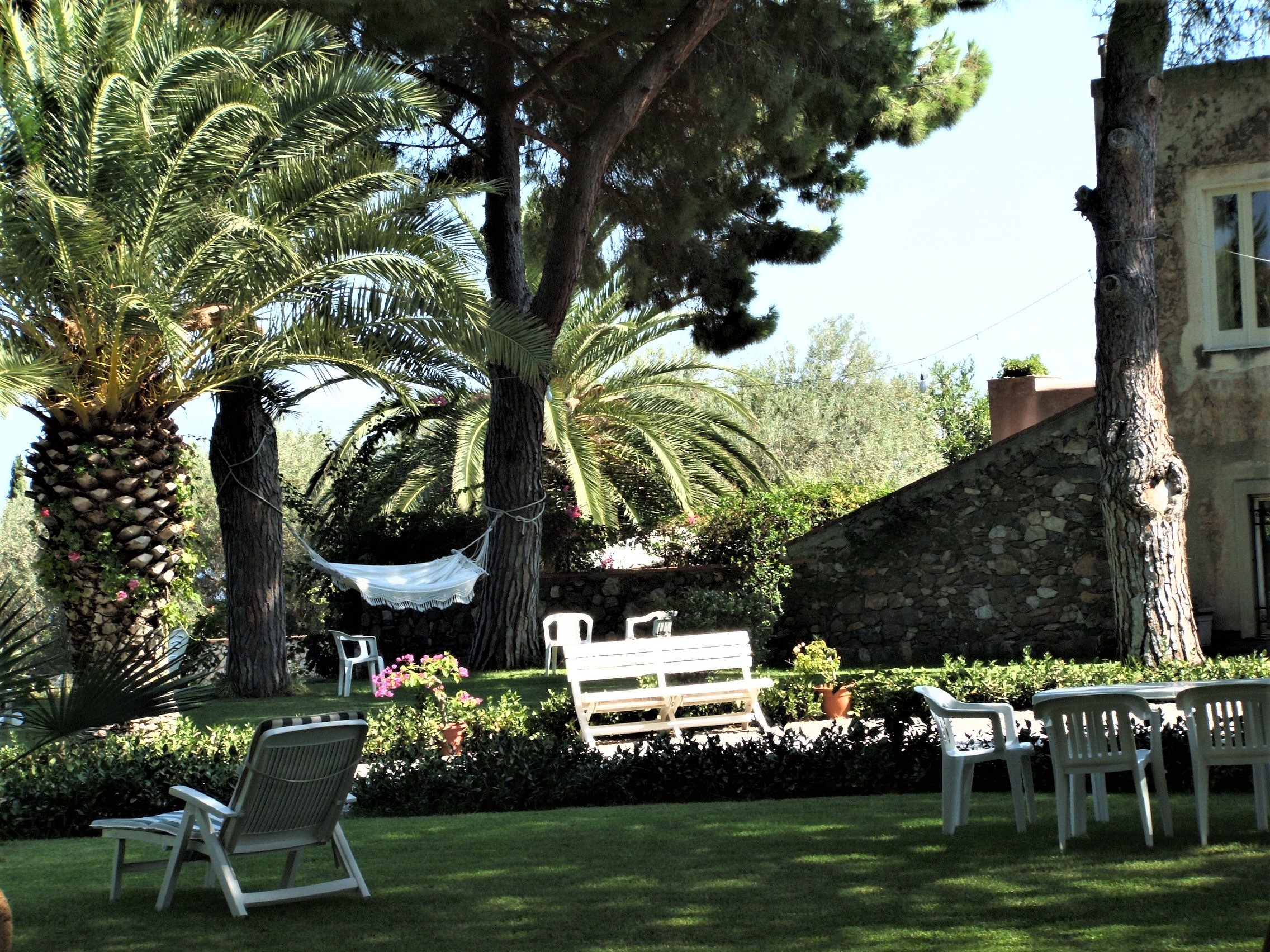 Picture featuring a beautiful garden with a few white chairs. A perfect venue when travelling during covid